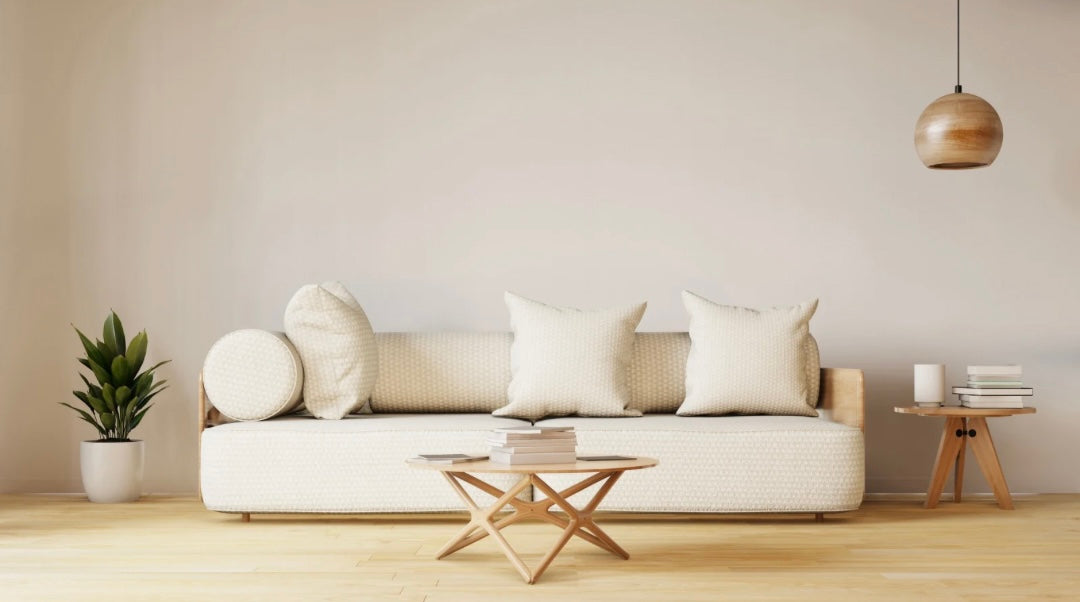 Stilvoll eingerichtetes Wohnzimmer mit hellen Holzmöbeln, Sofa, Beistelltischen und moderner Hängelampe