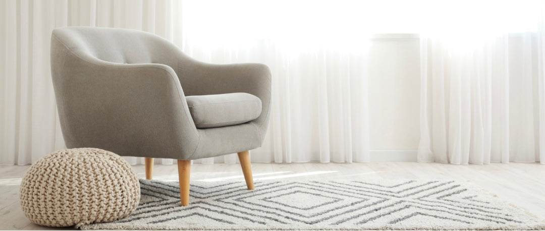 Moderner Teppich im Wohnzimmer, kombiniert mit Sessel und rundem Sitzkissen