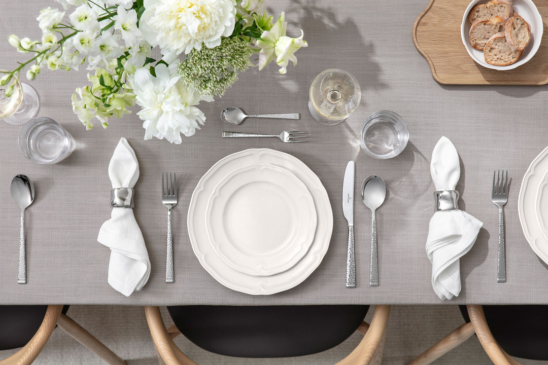 Assiettes et couverts Villeroy & Boch sur nappe grise