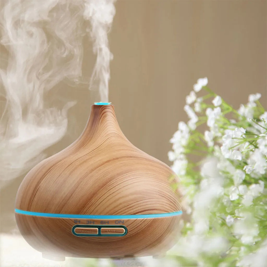 Aroma Diffuser in Holzoptik im Wohnambiente mit aufsteigendem Duftnebel und dekorativen Blumen