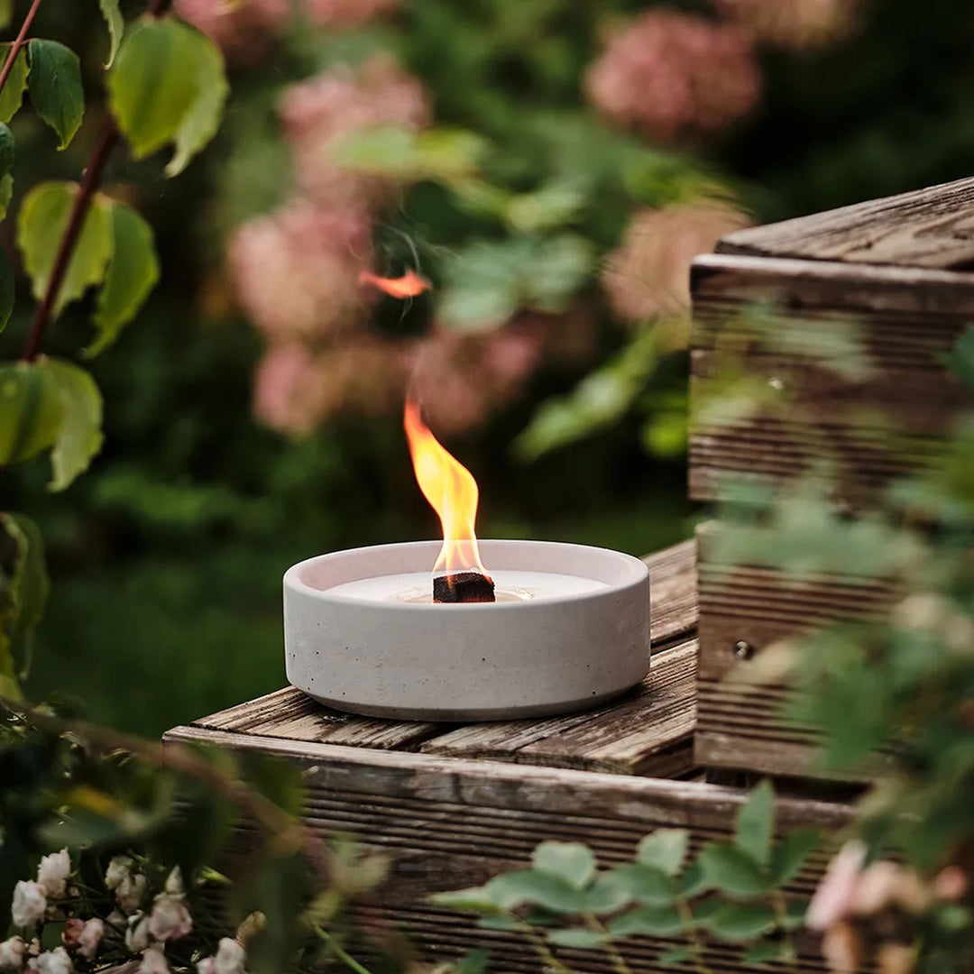 Beske Betonfeuer Suma L 19 cm, brennend auf Holzstufe im Garten
