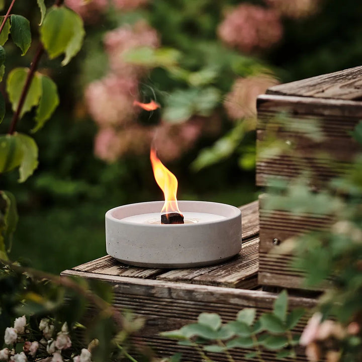 Beske Betonfeuer Suma L 19 cm, brennend auf Holzstufe im Garten