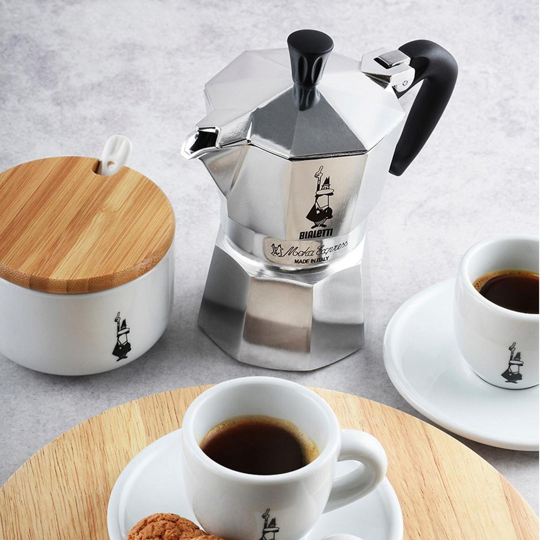 Bialetti Moka Express Silber, mit Espressotassen auf Holzbrett