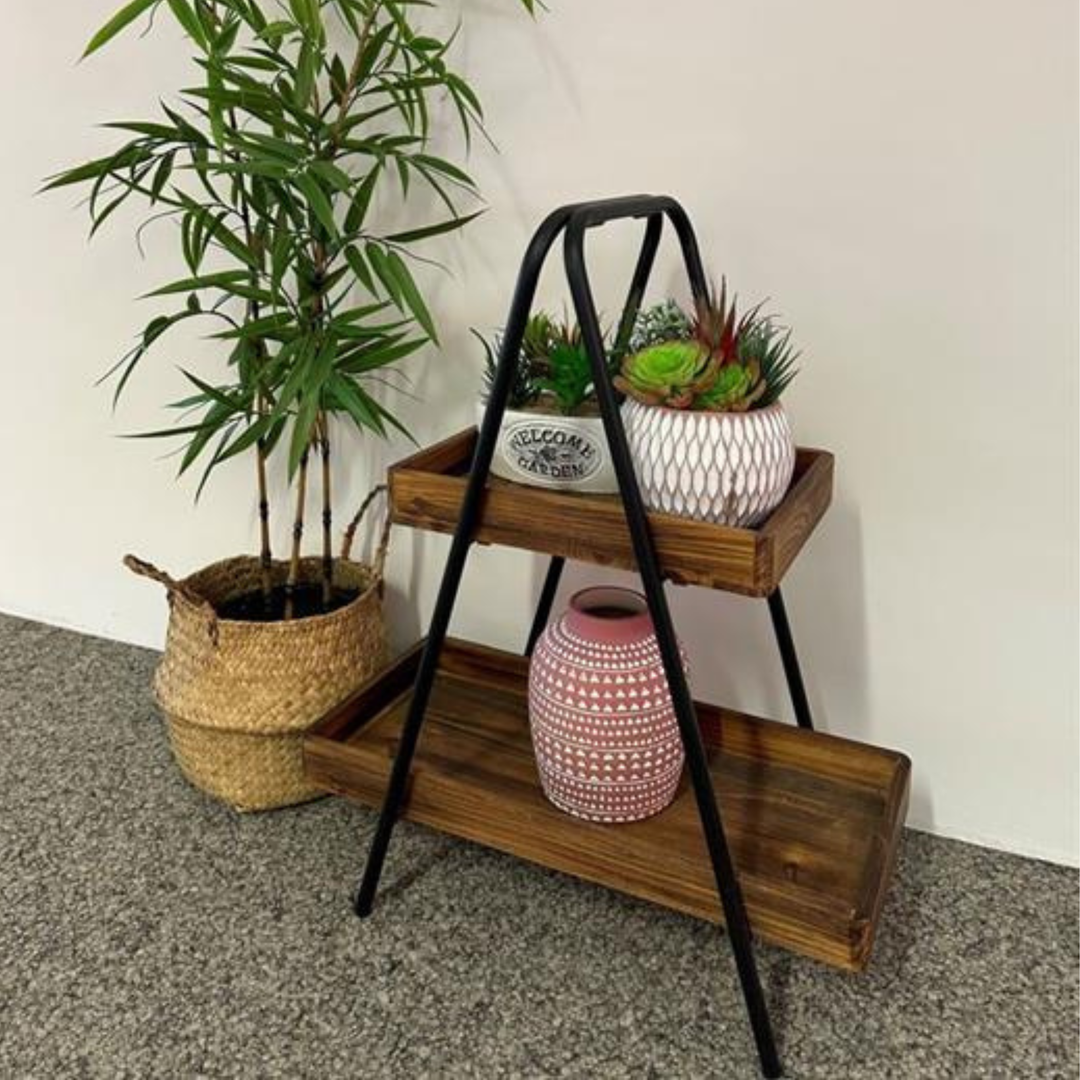 Etagere aus Naturholz und schwarzem Metall dekoriert im Wohnraum mit Pflanzen und Vasen