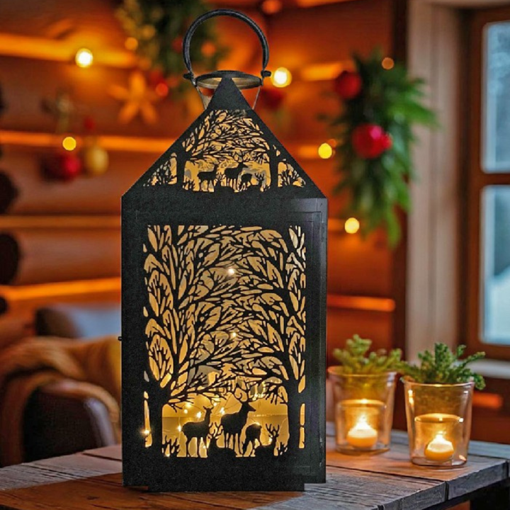 Lanterne Forest sur une table en bois à côté de deux bougies chauffe-plat