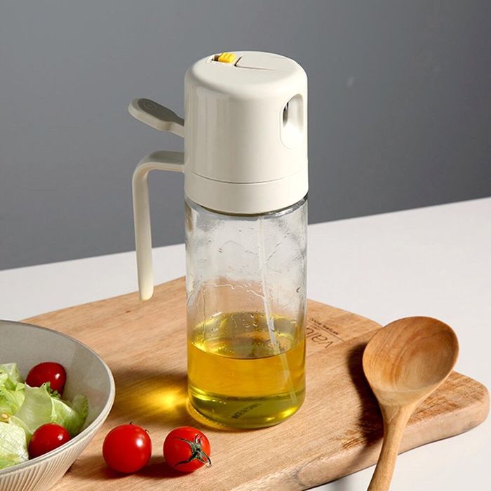 Oelsprueher 550 ml mit Olivenoel auf Kuechenbrett im Einsatz
