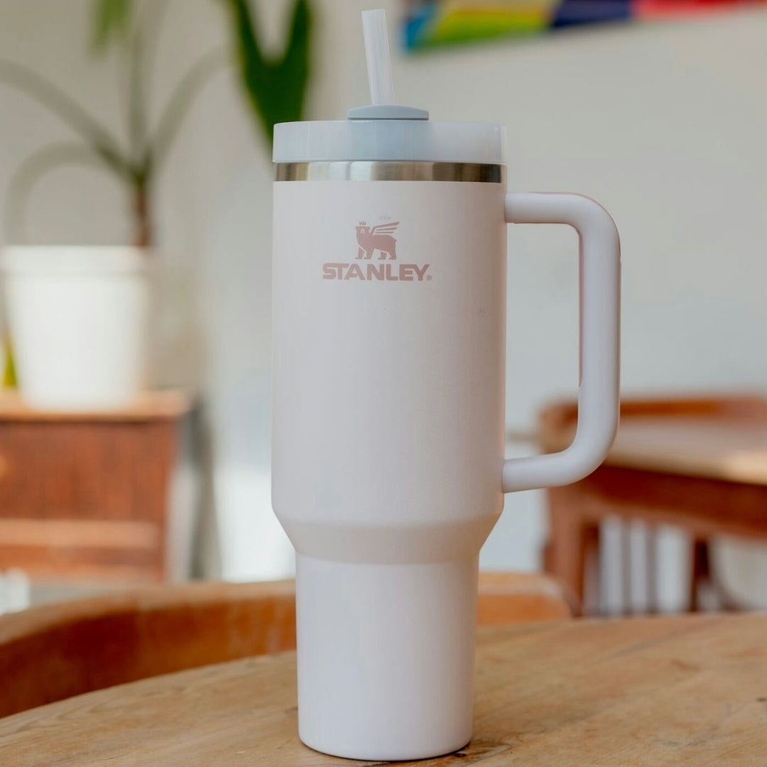 Stanley Quencher H2.0 in Rosé auf einem Holztisch