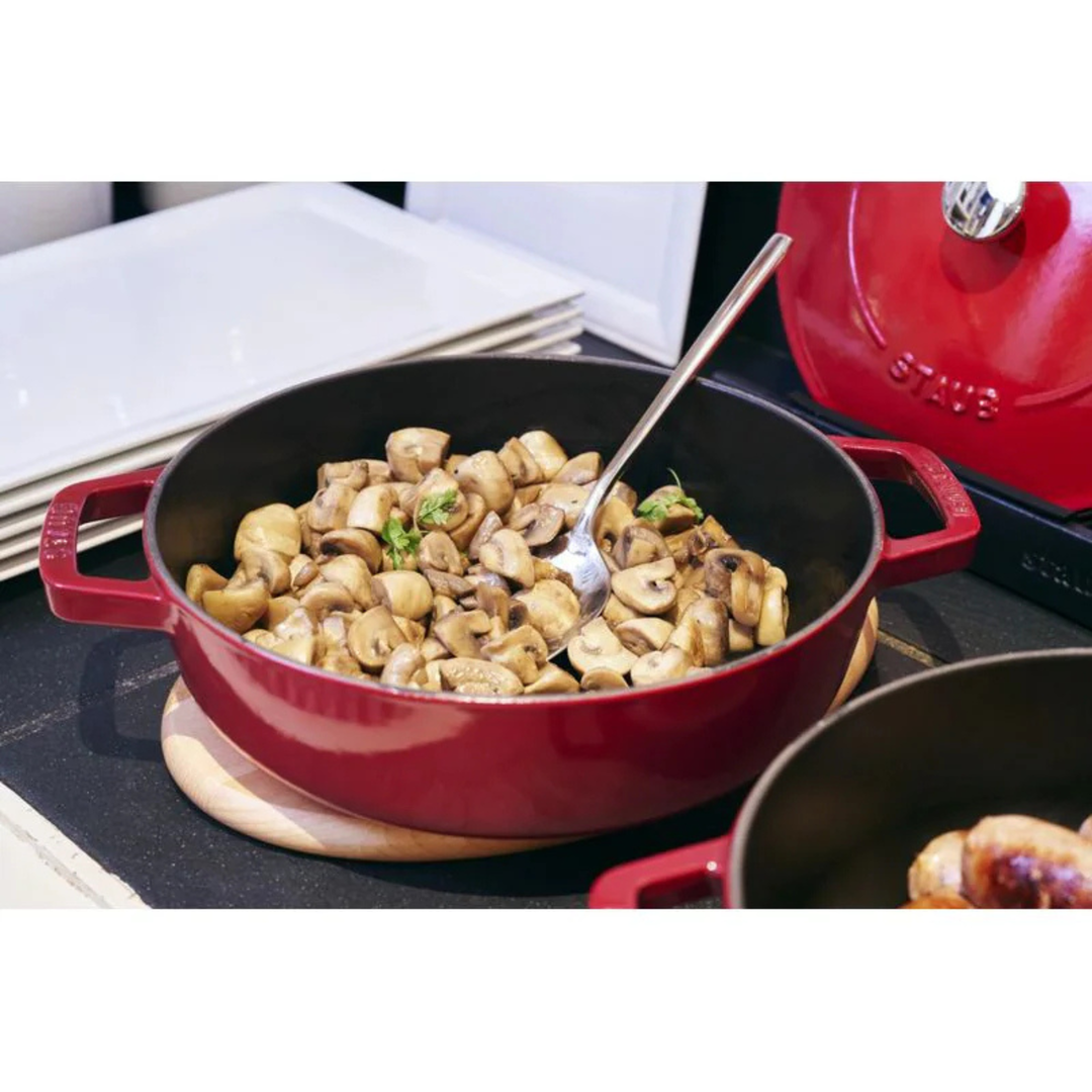Staub Chistera Bräter 28 cm aus Gusseisen beim Anbraten von Champignons auf dem Herd