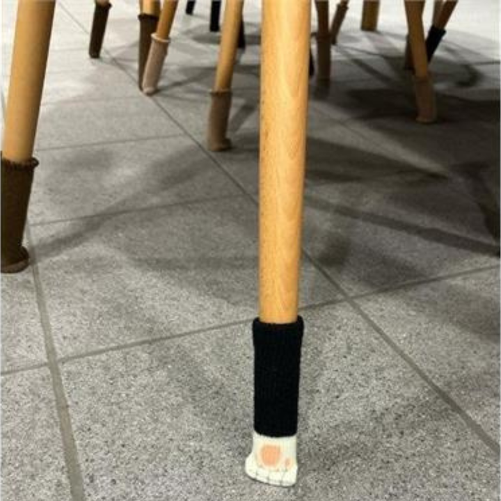 Chaussettes de chaise Uni, noir/blanc – pattes de chat, sur un pied de chaise en bois sur carrelage