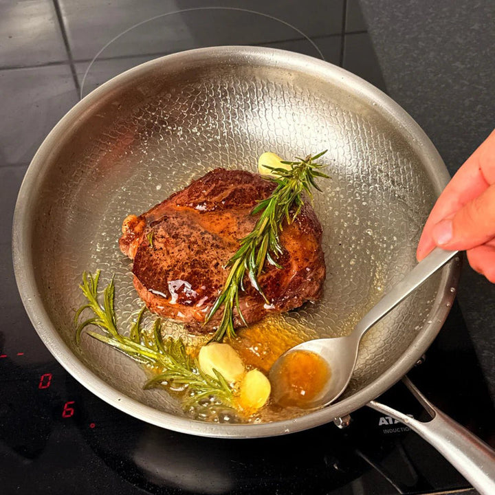 Poêle Titanium Pro, Titan Silver Edition, steak au romarin sur la plaque de cuisson