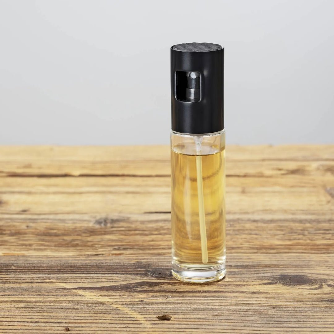 Vaporisateur à huile et vinaigre Wenko Nevo 100 ml, rempli d’huile sur une table en bois