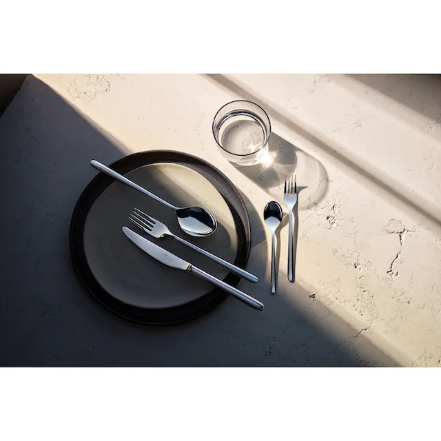 Set de couverts WMF Flame plus 30 pièces, sur une assiette sombre à table